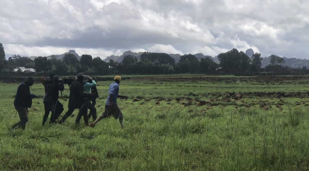 Vigilantes carry the remains of a member killed during Church service on 9 July near Jos. Photo by Masara Kim.