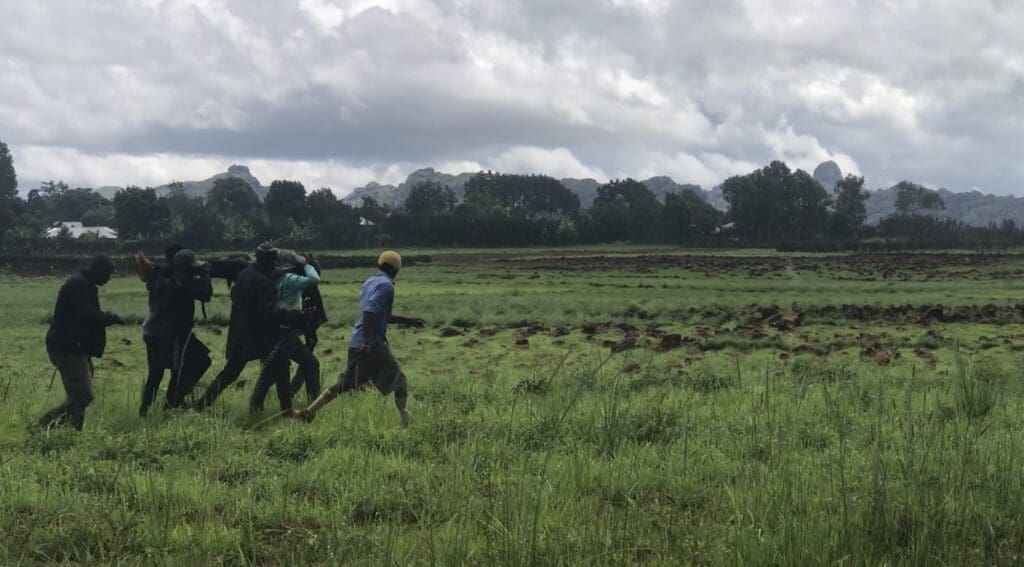 Vigilantes carry the remains of a member killed during Church service on 9 July near Jos. Photo by Masara Kim.
