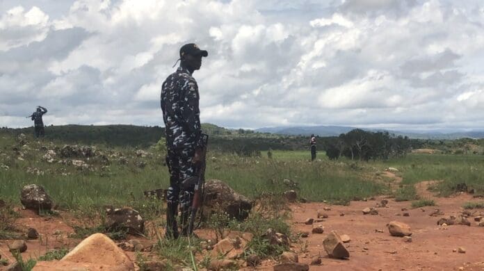 A policeman stands guard as vigilantes search for the corpse of a slain member in Riyom County near Jos on 9 July. Photo by Masara Kim.