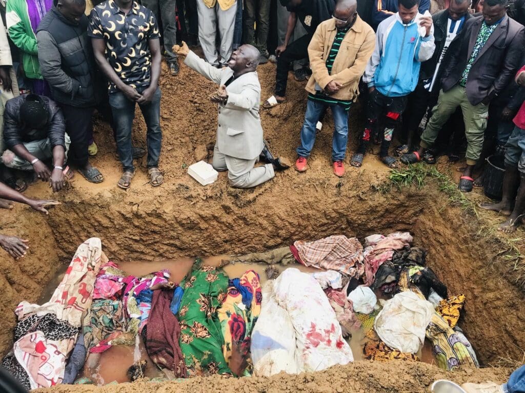 Rev. Ezekiel Dachomo weeps in front of 21 members of his Church killed by terrorists in the early hours of 10 August as they were given a mass burial in Heipang town near Jos