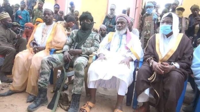Terrorist-bandits meeting at a conclave in Shinkafi Forest in Zamfara State in early 2021. At left in fatigues and face mask, bandit kingpin Bello Turji, to his right in white tunic is Sheikh Ahmad Gumi, chief negotiator. credit: Turji’s bandit gang.