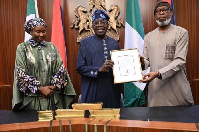 Minister of Solid Minerals Development, Dele Alake (right) presenting gold bars to President Bola Tinubu (middle).