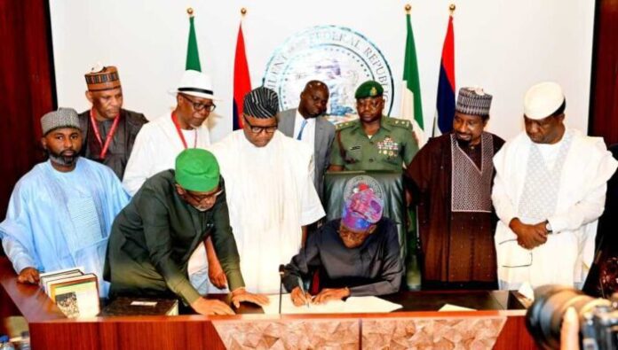 President Tinubu, flanked by key administration officials, signing the new national minimum wage bill. Photo credit: Daily Trust.