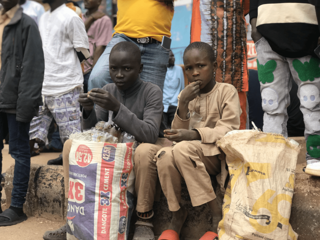 Boys eat crumbs from waste bags during #Endbadgovernance protest in Jos on August 4. Photo by Masara Kim