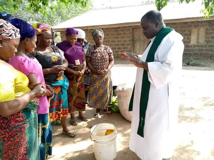 Fr. Cletus Bua praying with parishioners. courtesy Fr. Cletus Bua.