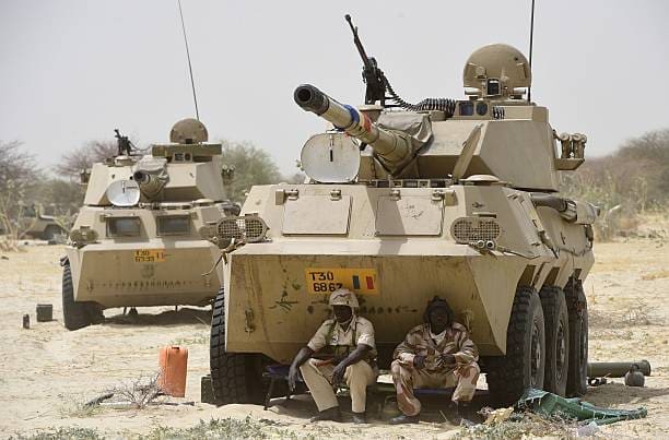 Soldiers in the Chadian military rest in the shade of an armored canon near the shore of Lake Chad on its eastern perimeter. Credit: Chadian Military.