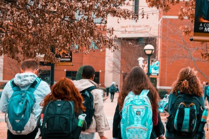 College students wearing backpacks as they head to class. Photo by Stanley Morales/Pexels.