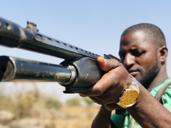 Volunteer defense guard in Mangu County takes aim. Credit: Masara Kim.