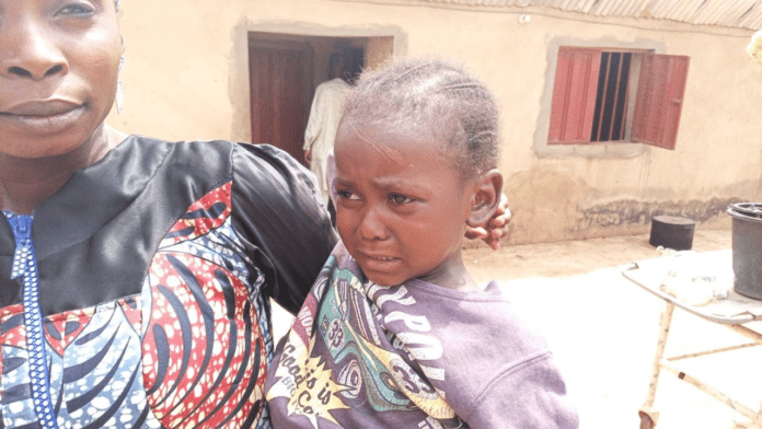 Five-year-old Tiho Nuhu, right, back home with family but still sick. Credit all photos: Mike Odeh James.