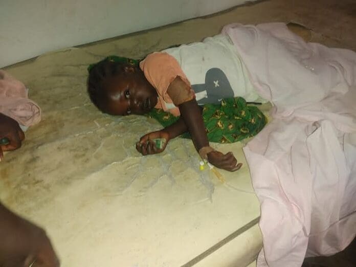 A baby survivor of ongoing attacks in Bokkos Plateau State and a mass burial of victims in Ruwi village. Credit Ayuba Matawal.