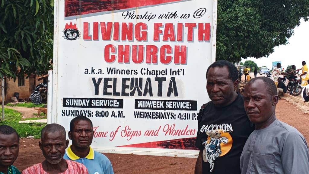 Elders of Yelewata pose next to church billboard in Yelewata. Photo by TruthNigeria Staff.