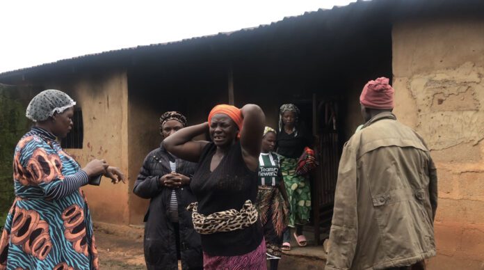 A resident cries in front of a house where nine members of a Pastor's family were burned on July 15. 