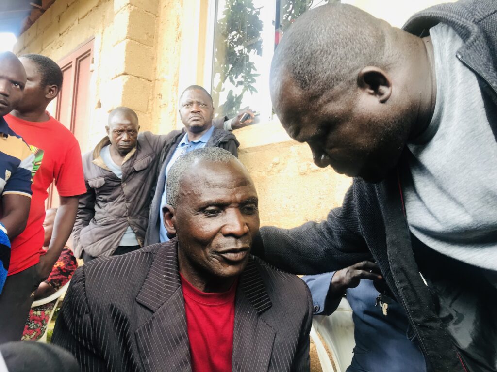 A reporter comforts Rev. Musa who lost nine family members in a terrorist attack on July 15.