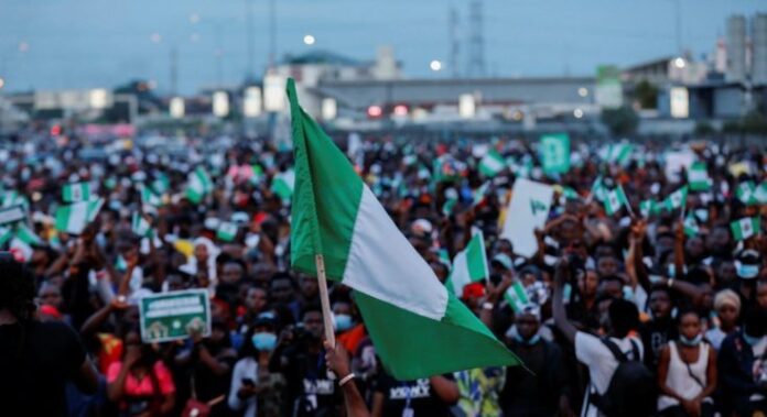 A crowd of young Nigerians brandishing the Nigerian flag. Credit: X/@NigeriaStories.