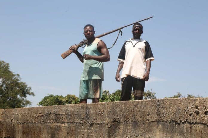 A rare picture of two local volunteer guards, with one carrying a homemade fabricated gunpowder on a bridge in Ugum village, Kajuru county Monday, 10th November, 2025) after the community was attacked by Islamists a day after (credit: Luka Binniyat).