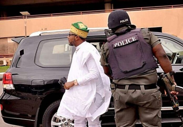Nigerian businessman E-Money with his police escort opening his car door. Credit: E-Money/Instagram.