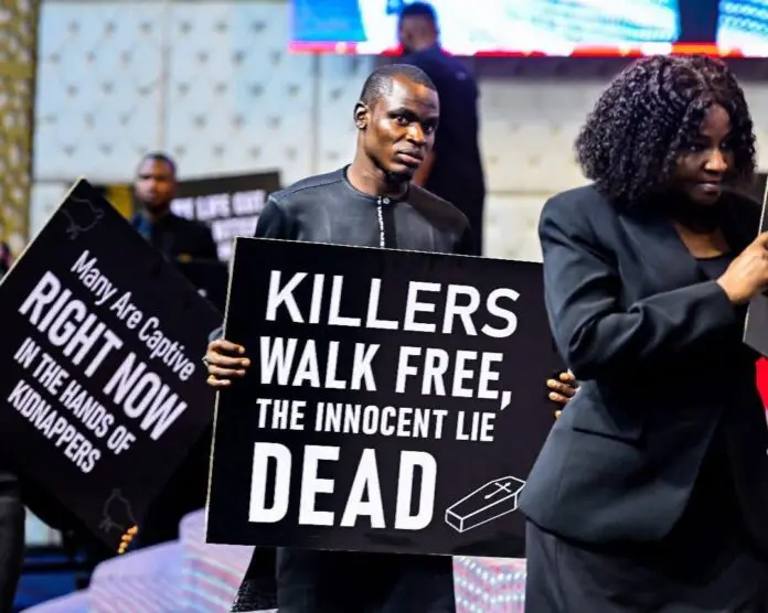 Members of Family Worship Centre holding placards in church. Credit: Sarah Omakwu_Facebook