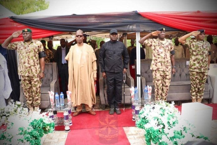 Nigerian Minister of Defense, Gen. Christopher Musa (rtd) in a dark safari suit , to his right, Governor of Borno State, Prof. Abbagana Zulum, flanked by serving Generals pay tribute to the fallen soldiers, Wednesday April 15, 2026. Photo by: @HQNigerianArmy on X.