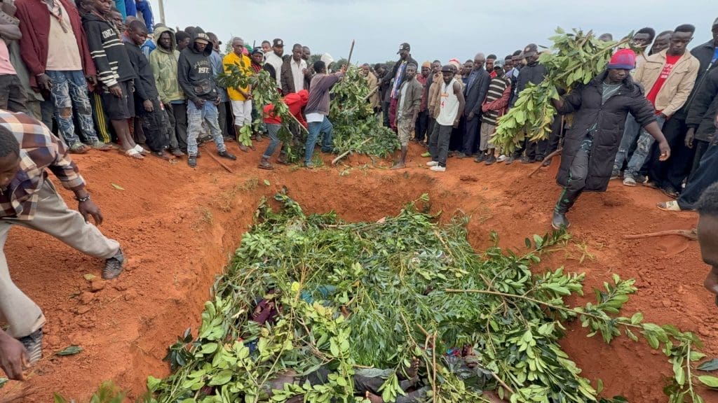 Residents cover deceased victims of June 22 attack in Kawel with leaves prior to mass burial. Photo by by Masara Kim/TruthNigeria.
